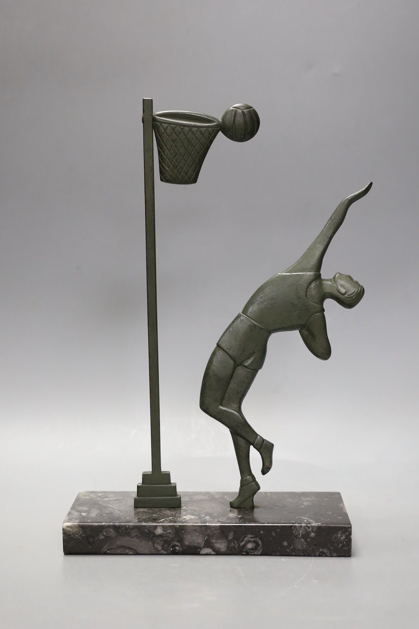 An Art Deco bronze on marble base, of a basket ball player, 32cms high